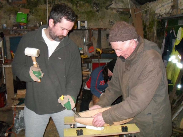 Stephen and Loughie work on the gouging out of the hull. Photo: Douglas Cecil